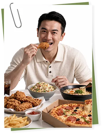男士大口吃炸鸡,桌上摆满披萨、薯条和外卖餐食